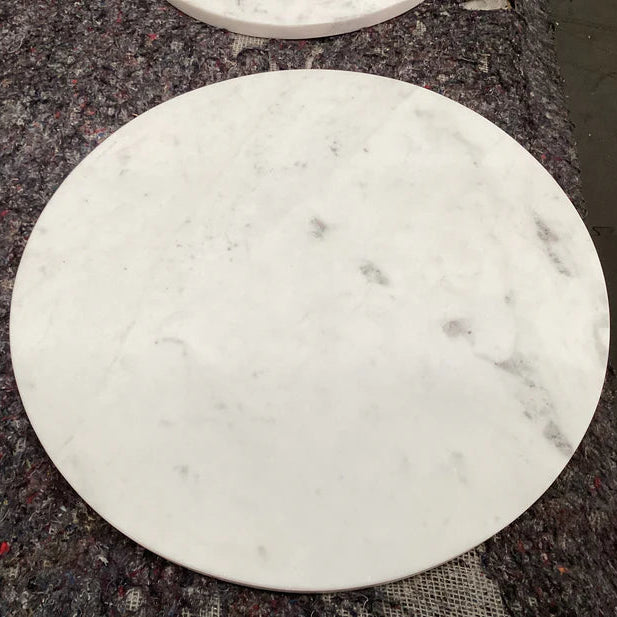 Round marble coaster on a dark textured surface