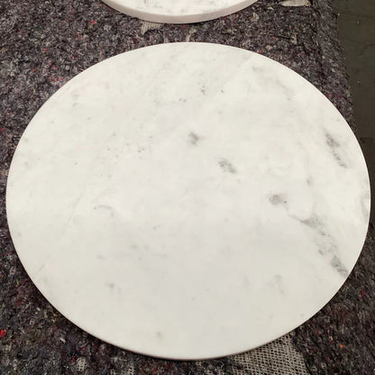 Round marble coaster on a dark textured surface